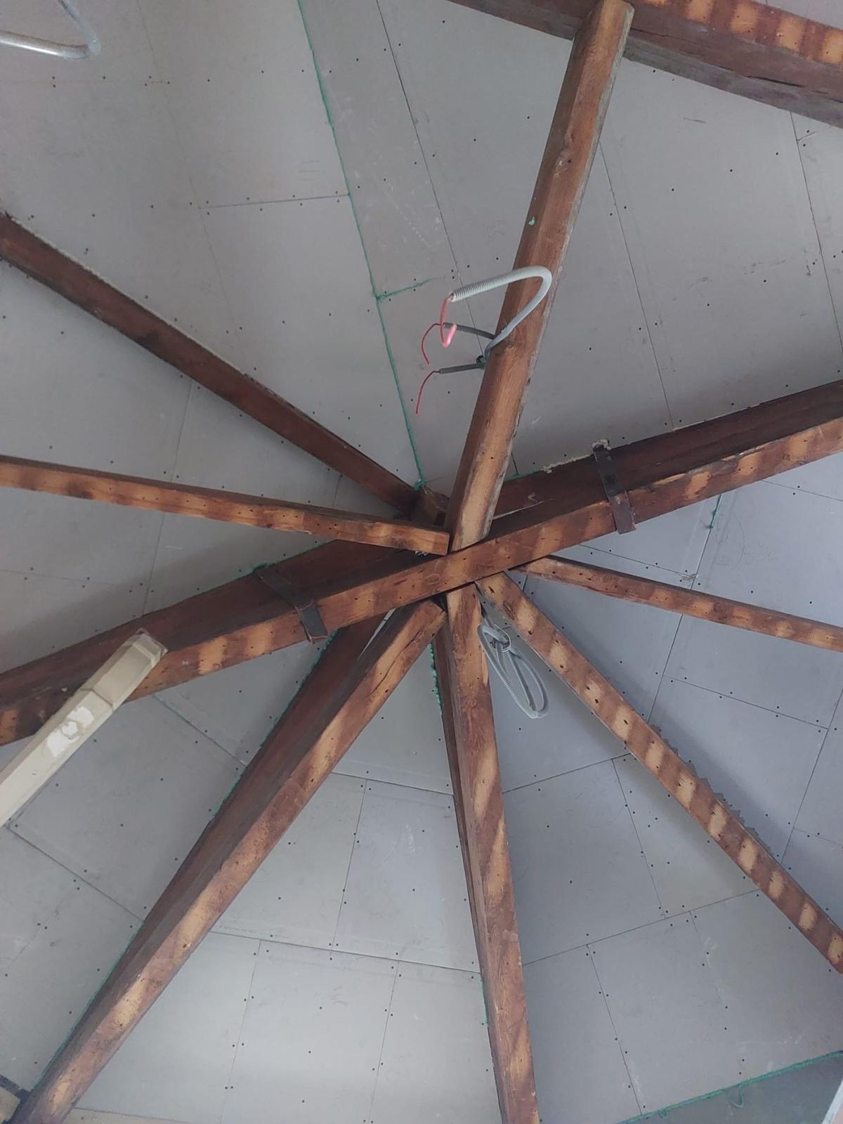 Houten kapconstructie met spanten, waartussen het plafond met gipsplaat is dichtgezet