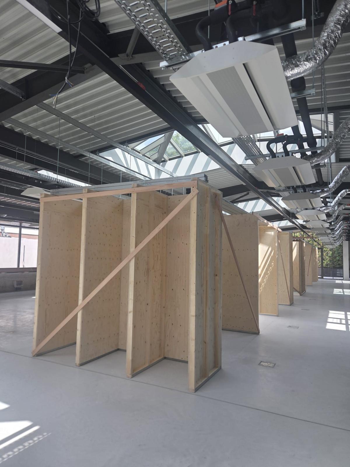Plywood cabines met schoren onder de daklichten van een bedrijfshal