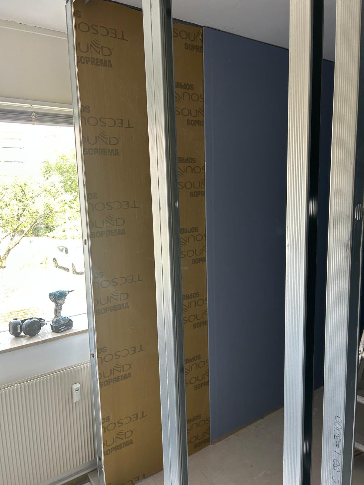 Metalstud frame met Tecsound membraan tussen de stijlen, in een ruimte met raam en radiator